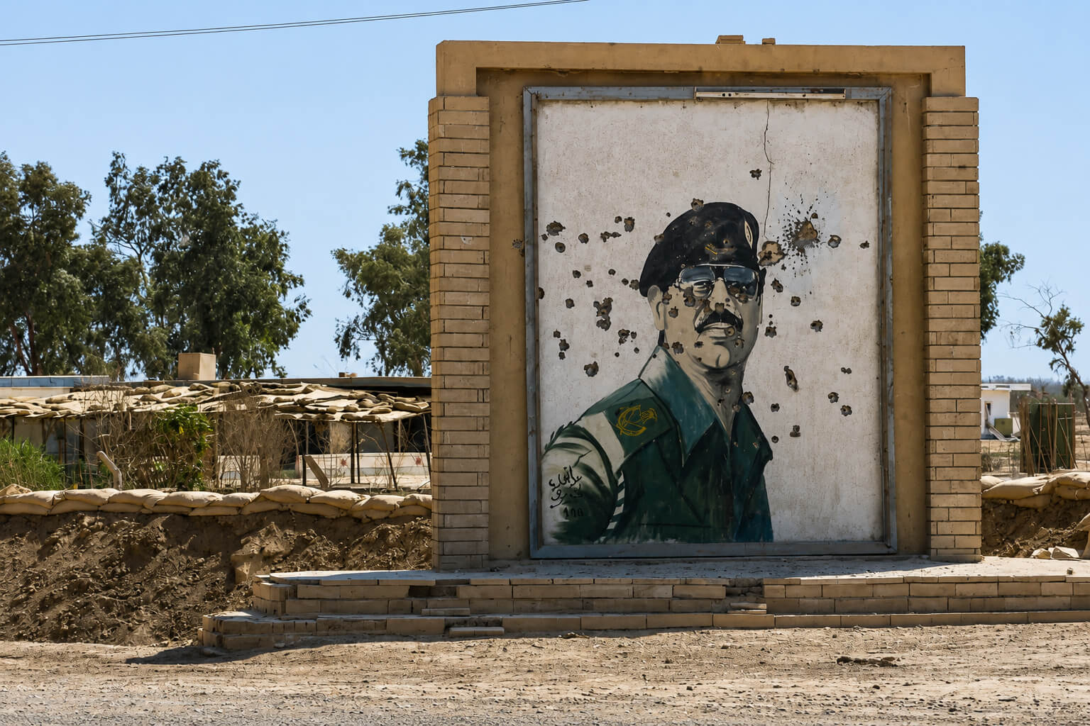 Un retrato de Saddam Hussein con varios impactos de bala.