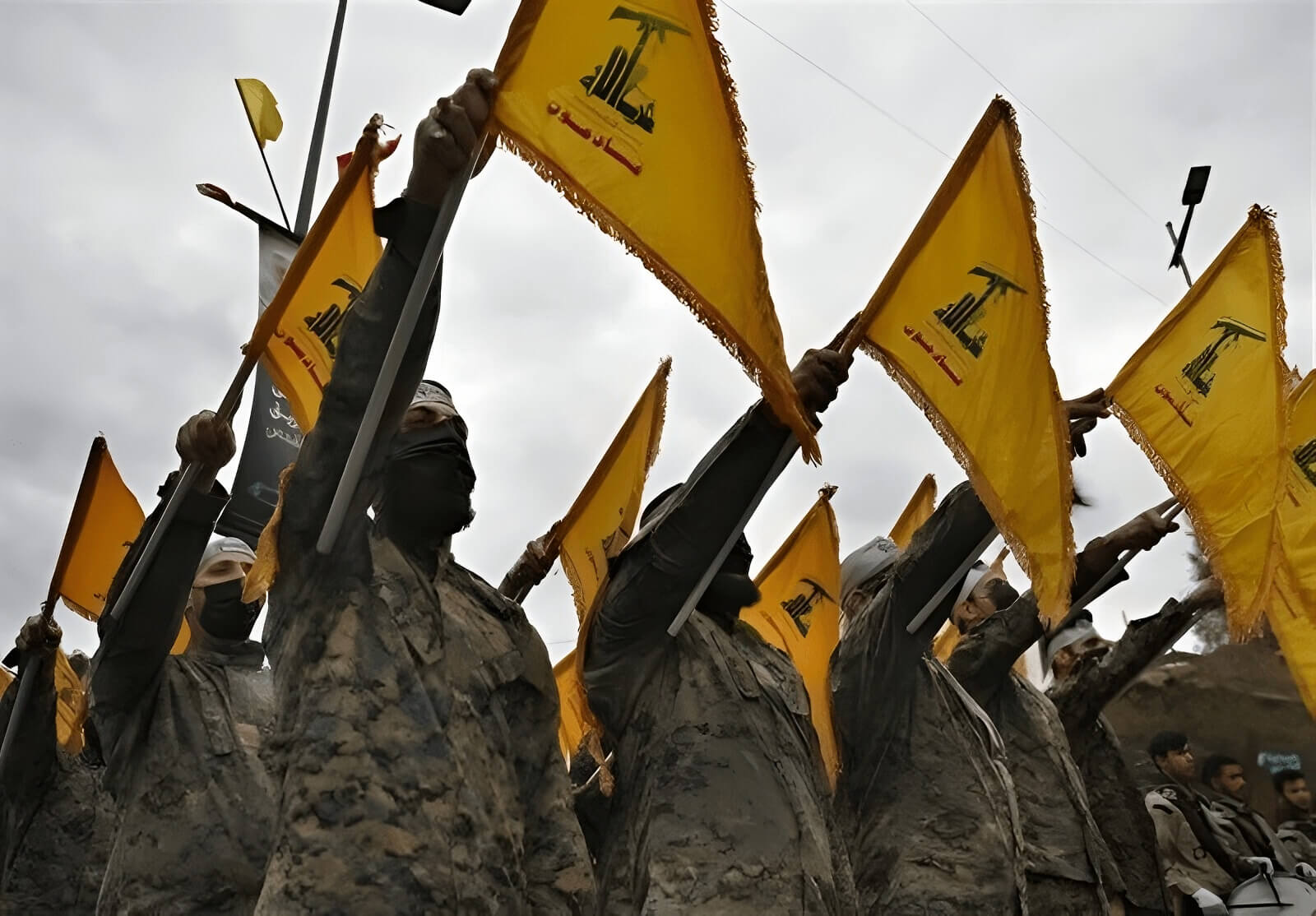 Combatientes de Hezbolá portan banderas de la organización chií.