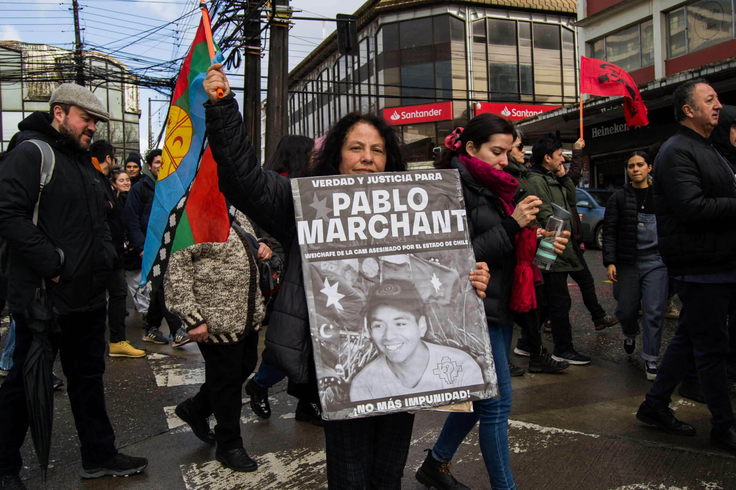 Una manifestante sostiene un cartel en el que exige justicia por la muerte de Pablo Marchant, joven militante mapuche de la Coordinadora Arauco Malleco, que recibió un disparo en la cabeza en 2021 durante un enfrentamiento con las fuerzas policiales